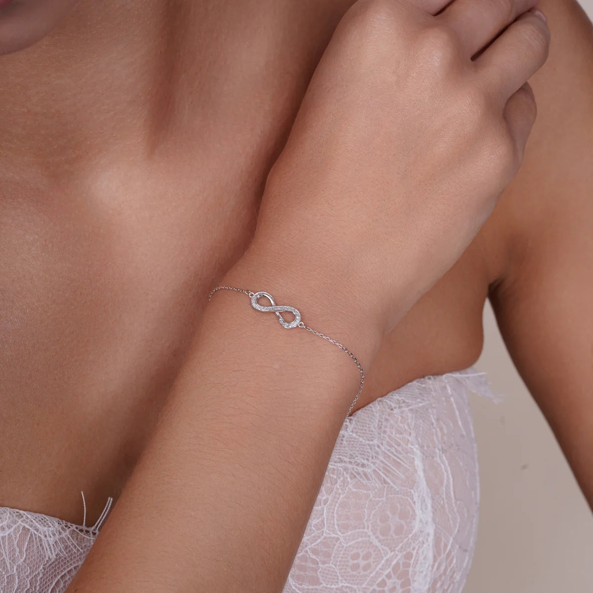 Sterling silver lab grown diamond infinity bracelet shown worn on the wrist