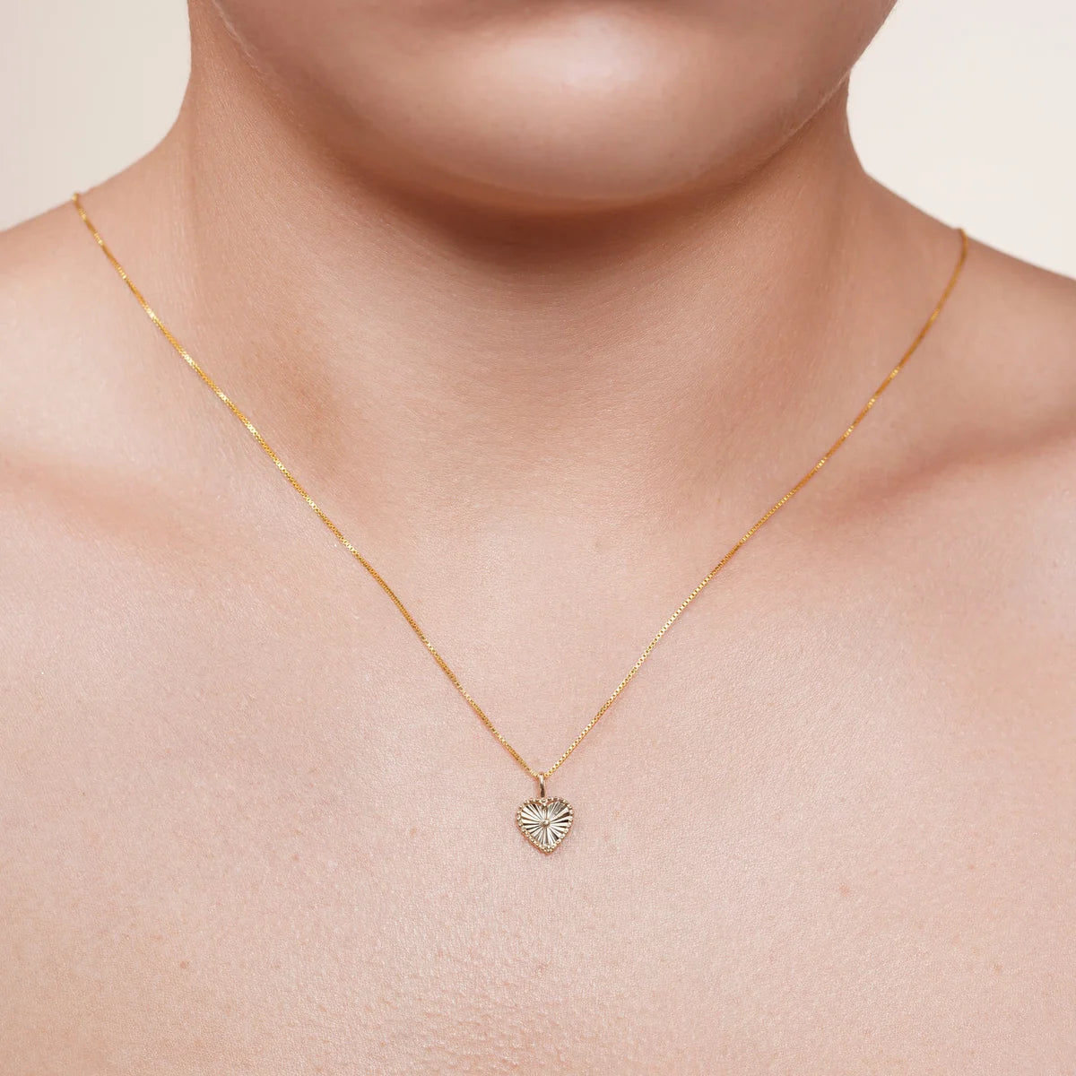 14 karat gold heart pendant shown hanging on a chain