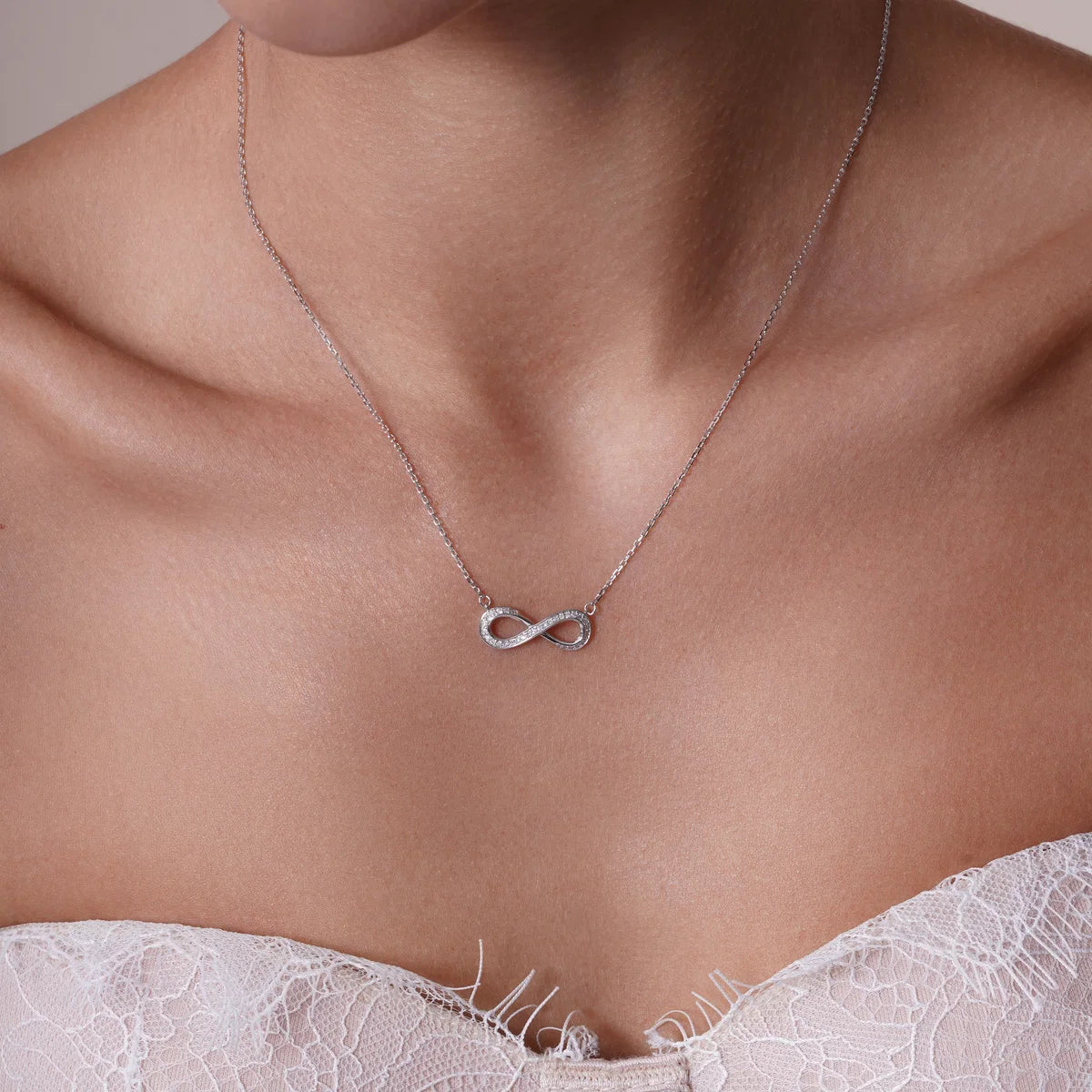 Sterling silver diamond infinity necklace shown worn at the collarbone