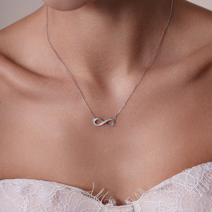 Sterling silver diamond infinity necklace shown worn at the collarbone