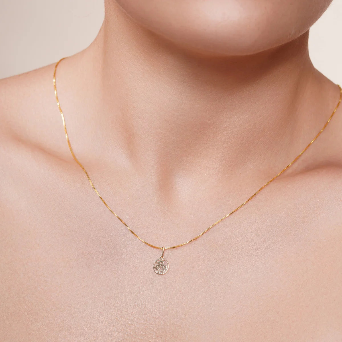 14 karat gold sunflower pendant shown on a chain